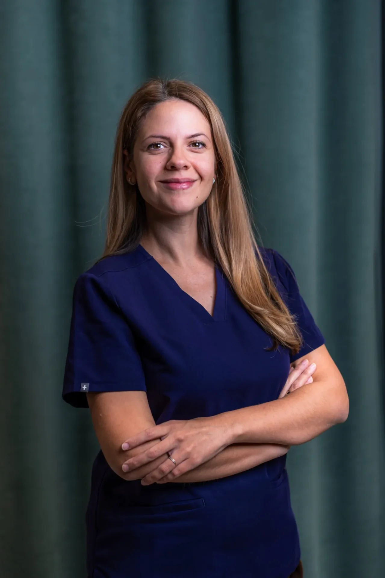 Porträt von Dr. Mila Ivanov, Zahnärztin im Zahnärztehaus Zürich in blauer Praxisbekleidung.