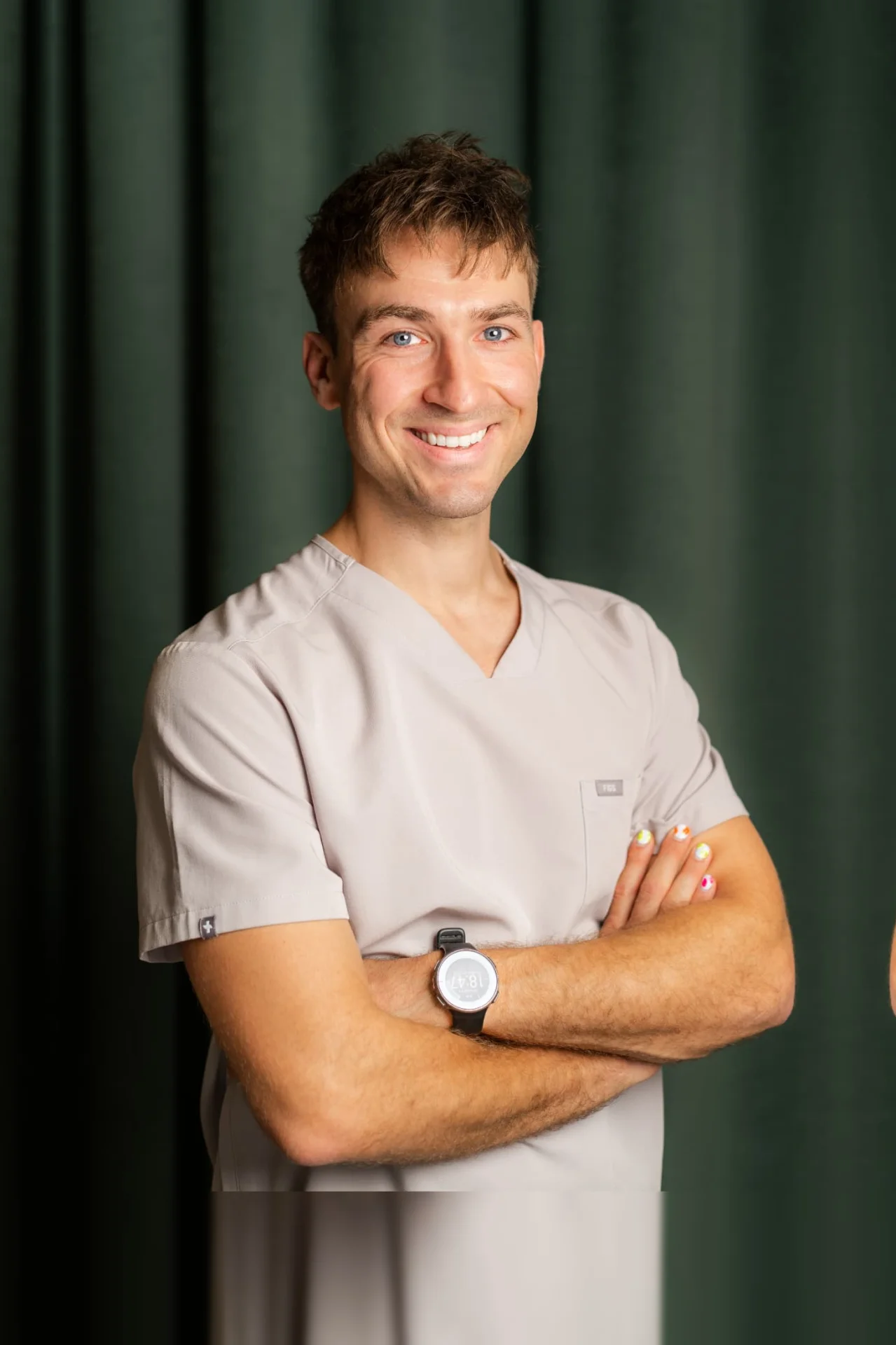 Porträt von Dr. med. dent. Philipp Meyer, Kieferorthopäde in Zürich, im Zahnärztehaus Zürich in grauer Praxisbekleidung.
