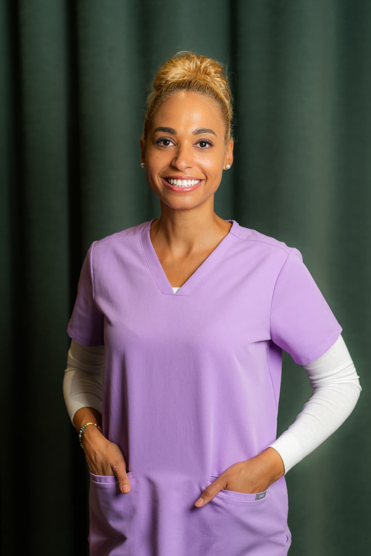 Porträt von Jennifer Mafuta, Dentalhygienikerin im Zahnärztehaus Zürich in lilafarbener Praxisbekleidung.