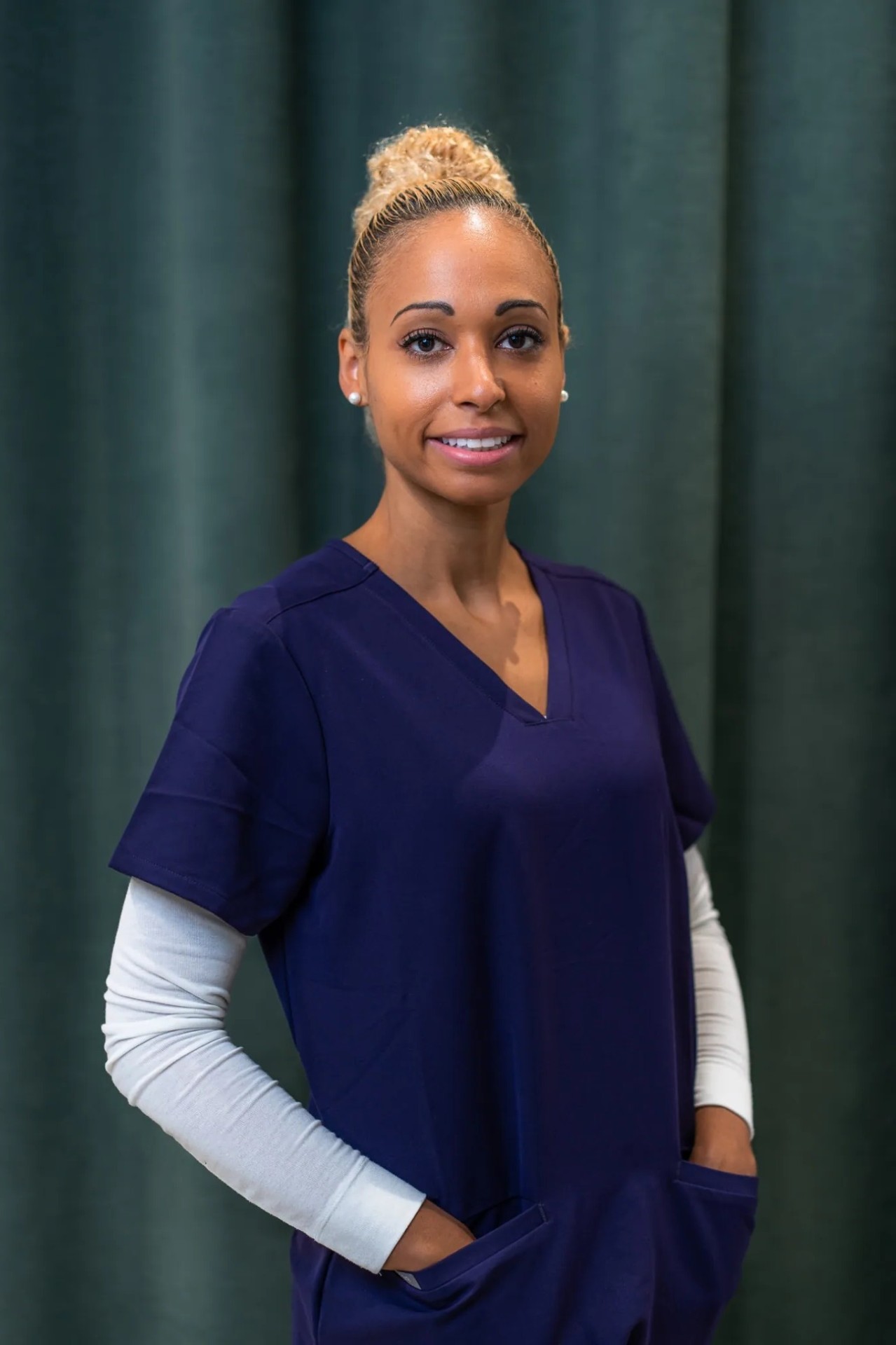 Porträt einer Mitarbeiterin im Zahnärztehaus Zürich in blauer Arbeitskleidung.