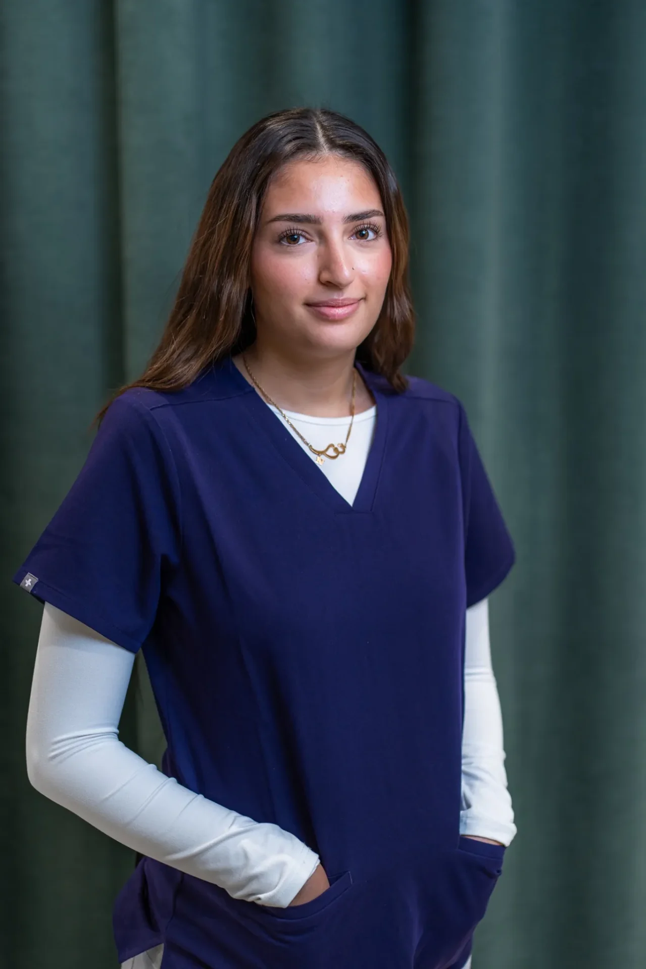 Porträt von Nour Mohammed im Zahnärztehaus Zürich in blauer Praxisbekleidung.